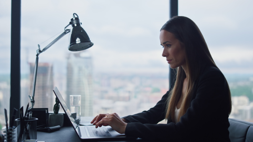 Focused businesswoman working on laptop computer in home office. Female manager typing on laptop keyboard indoors. Portrait of serious business woman looking at laptop screen in office | Shutterstock HD Video #1057689469