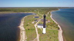 Beautiful panoramic aerial 4K video from flying drone on sunny Sorve lighthouse. The cylindrical concrete lighthouse in Saaremaa island Estonia (Series)