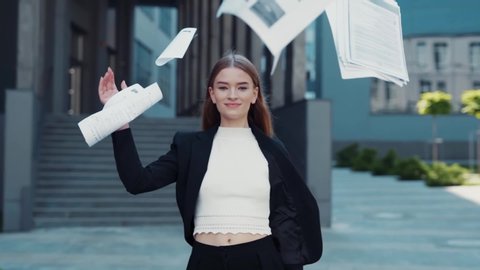 Happy woman finished the project, throwing papers, freedom after work, success in business. Businesswoman smiles and laughs, winner won the competition, emotions from victory. Student defended thesis
