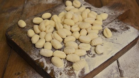Gnocchi with potatoes. Traditional italian food from Rome, Sardinia, south of italy. Homemade gnocchi with parmesan, egg, cornmeal (semolina). On a wooden table. 4k video