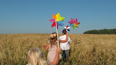 little boy, girl children child running with toy wind turbine in hand at summer nature outdoors Wheat field Happy kid playing having fun pinwheel, Vacation travel childhood happy family holiday slowmo
