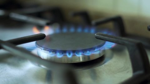 The Process of Lighting a Gas Stove in the Kitchen, Close-up. A Burning Flame from the Gas on the Stove.