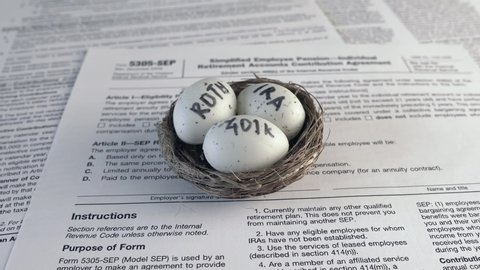 Conceptual composition. Pension savings. Individual retirement account. Three eggs with the inscriptions IRA, 401k, Roth lie in the nest against the background of the 5305-SEP form. Close-up