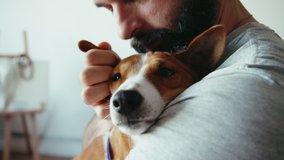 Close up shot of young bearded man hugging and kissing his cute friend brown basenji pure breed dog. Animals and human friendship - Powered by Shutterstock - Get 15% off with code: PIKWIZARD15
