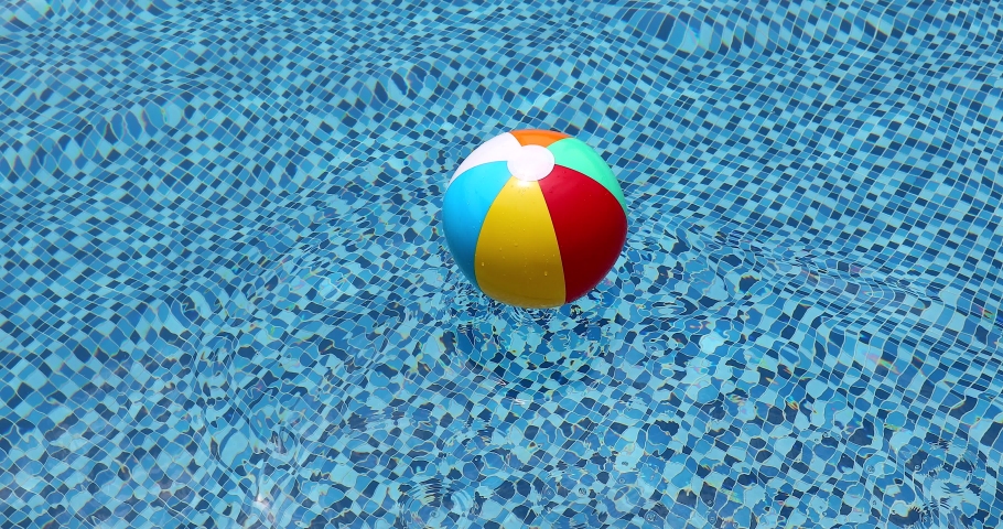 Beach ball in pool. Colorful inflatable ball floating in swimming pool, summer vacation concept. Royalty-Free Stock Footage #1057729693