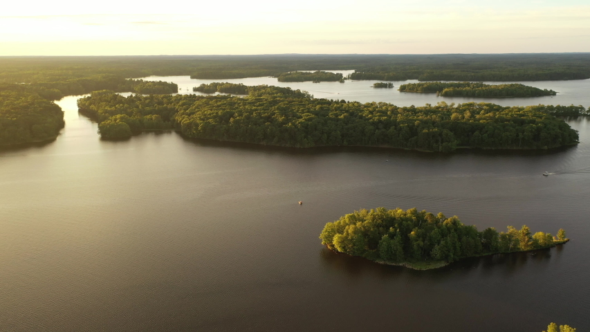 Aerial American Midwestern landcape. Scenic lake, forest at sunrise. Nature of the Midwest, local tourism . Drone flying low over the water