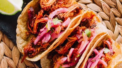 Authentic Mexican tacos filled with cochinita pibil (shredded meat marinated with onion)