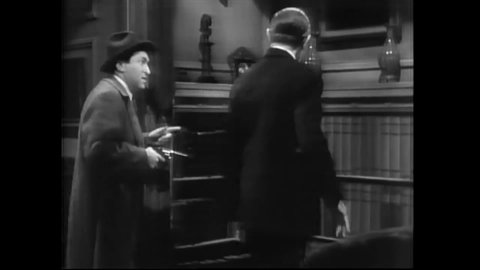 CIRCA 1939 - In this classic horror comedy, a detective helps an investigator (Harry Ritz) solve a mystery by showing him secret passageways.