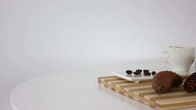 Cup of coffee with chocolate candies with gift box on spinning table background.