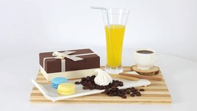Cup of coffee with chocolate candies and gift box on spinning table background.