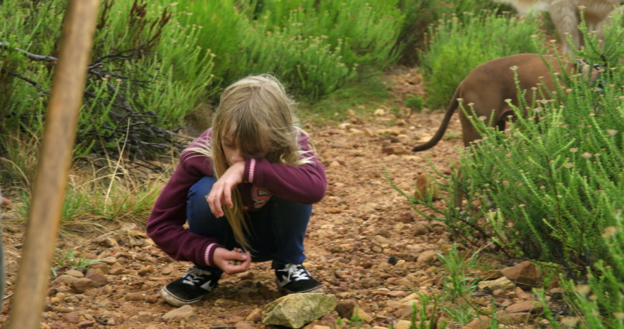 WS TS Girl (8-9) crouching on path and picking up pebbles / Cape Town, South Africa