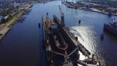 Aerial view of the ship in floating dry dock under repair by sandblasting in Riga, Latvia.