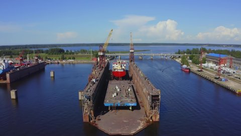 Aerial view of the ship in floating dry dock under repair by sandblasting in Riga, Latvia.