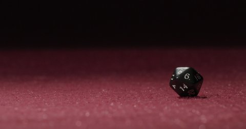20-sided dice rolling in slow motion across a carpeted surface.
