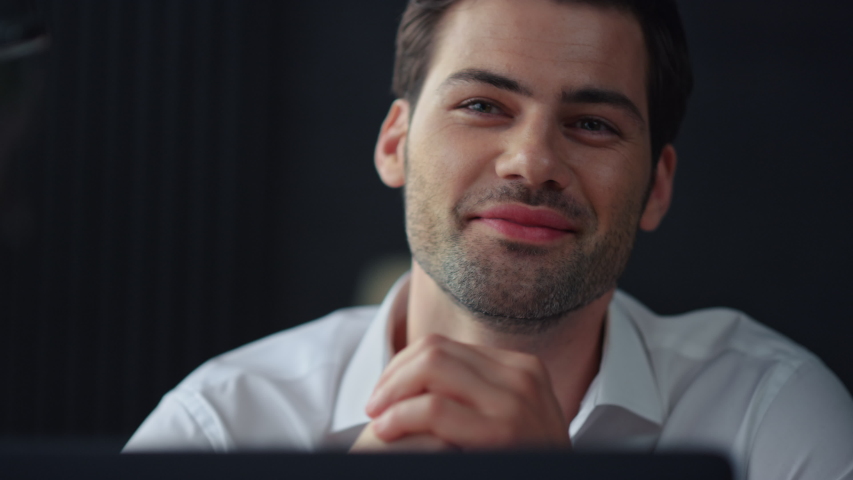 Happy businessman sitting at remote workplace with laptop. Portrait of smiling professional holding hand at face. Closeup dreamy business man dreaming in office. Top manager working in office Royalty-Free Stock Footage #1057746811