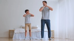 Father Day,Family fitness at home, Father coach, Sports kid, Fun gymnastics. Dad and son doing physical exercise squatting together while standing on the floor at home
