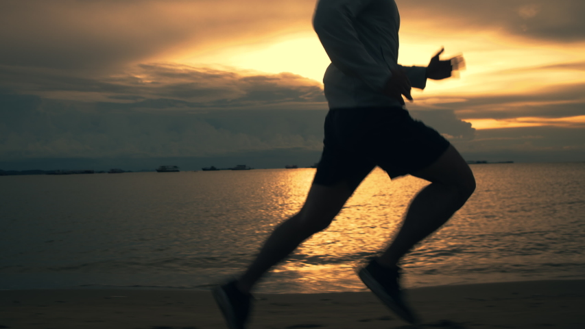 Silhouette of asian sportsman running on the beach beautiful sunset. Athlete training exercise workout health care concept. Royalty-Free Stock Footage #1057755673
