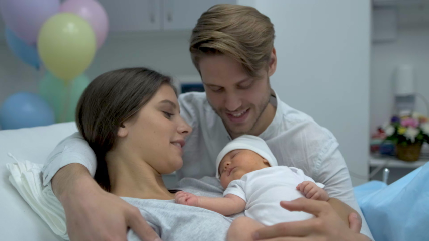 Happy family. Newborn baby resting in mother and father arms. Parents right after delivery in maternity hospital. Woman holding her new born child after birth labor. Childbirth motherhood, 4 K slow-mo Royalty-Free Stock Footage #1057758148