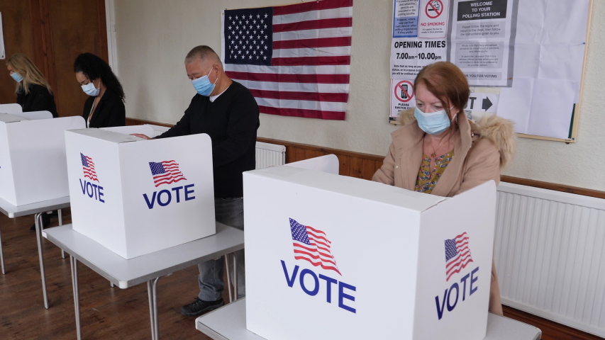 4K: Voters voting at Polling Place of the USA Election.  People Stood at booths wear Face Masks. Gimbal Walking shot. Stock Video Clip Footage Royalty-Free Stock Footage #1057761451