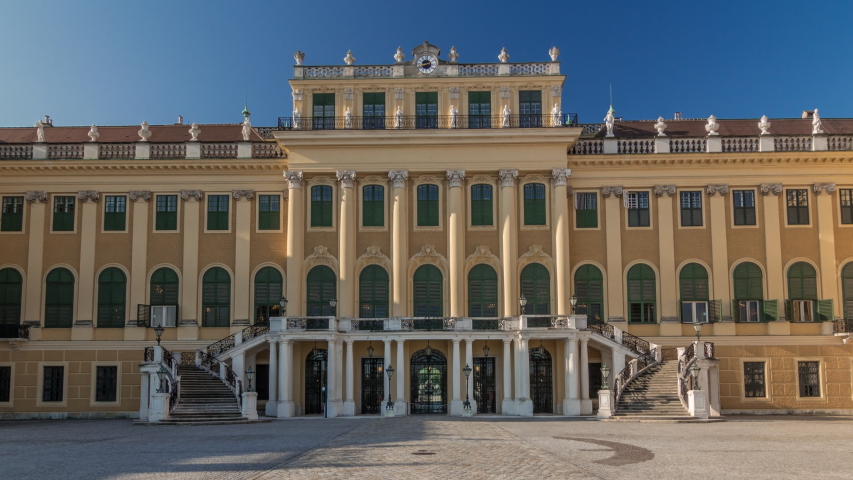 Front view of famous Schonbrunn Palace timelapse hyperlapse with Great Parterre garden and staircase in Vienna, Austria. Blue sky on a background