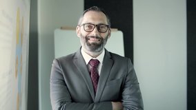 Portrait of Caucasian bearded middle-aged top manager in office suit and glasses. Successful happy businessman standing, smiling and looking at camera. Human resources, personnel and business concept - Powered by Shutterstock - Get 15% off with code: PIKWIZARD15