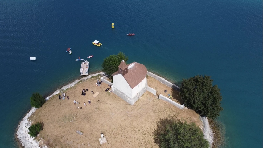 Exceptional aerial view of a chapel located on a small island. Boats, Canoe Kayak and Paddle cruising around this unusual place.