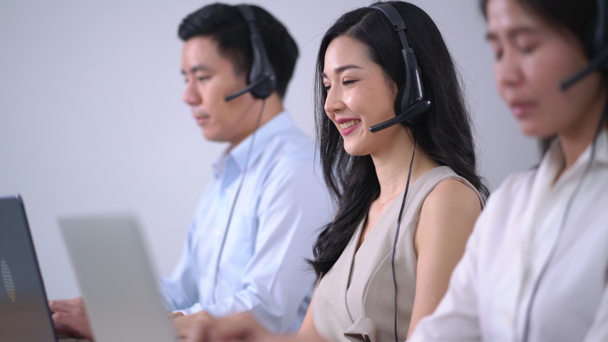 Group call center operator using laptop and headset customer support service with friendly | Shutterstock HD Video #1057781203