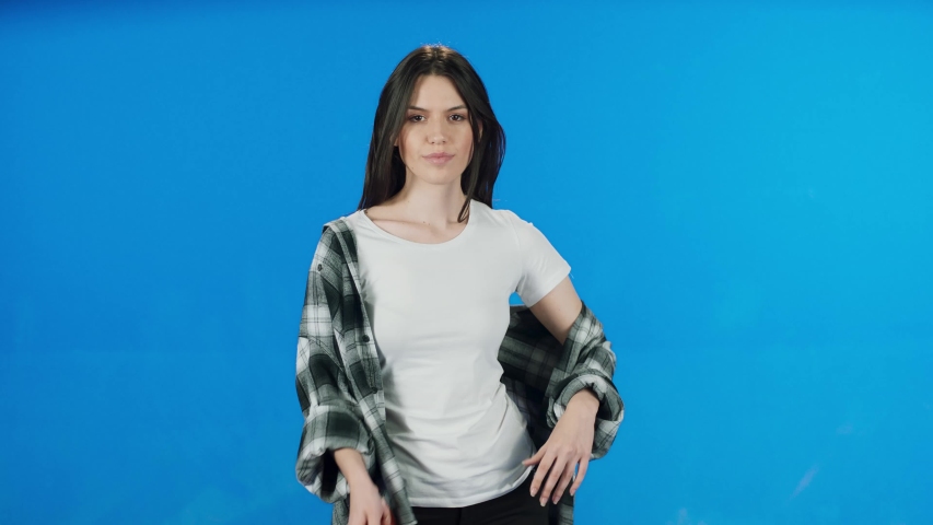 Fashion pretty pretty woman holding red umbrella over blue background wearing t-shirt and shirt.Woman with umbrella on blue background.