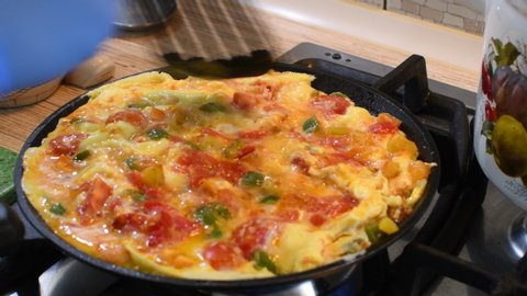 cooking scrambled eggs. omelet with vegetables. homemade food.