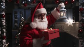 Santa Claus With Сandle And a Bag of Presents Walking Around Room Background of Home New Year Decor and Christmas Tree. December Evening Before Xmas Eve. Concept New Year Dream Christmas Spirit. - Powered by Shutterstock - Get 15% off with code: PIKWIZARD15