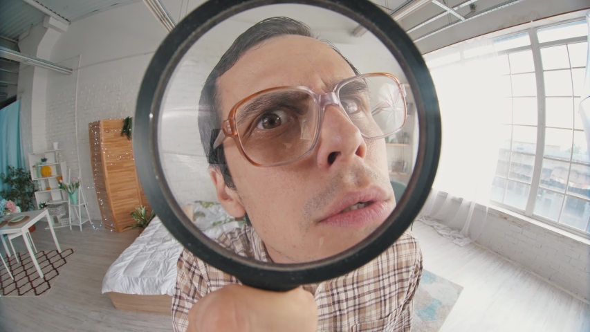 Nerd looks through magnifier glass | Shutterstock HD Video #1057787176