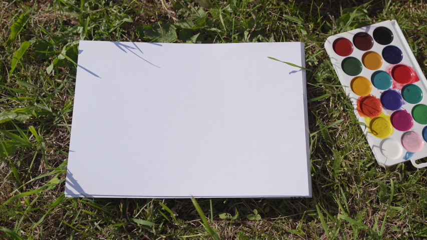 The child leaves a trail of paint with his palm.