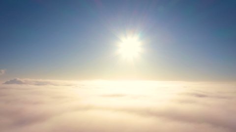 shining sun and clear blue sky while flying above the overcast clouds
