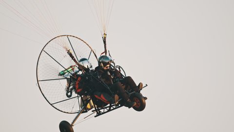 Tandem Paramotor Gliding - two men flying and gliding in the air. High quality photo