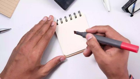 Top view of man hand writing to do list on a notebook 