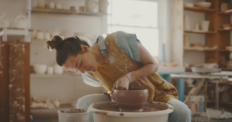 Talented artist makes clay bowl on pottery wheel, handmade creative artist