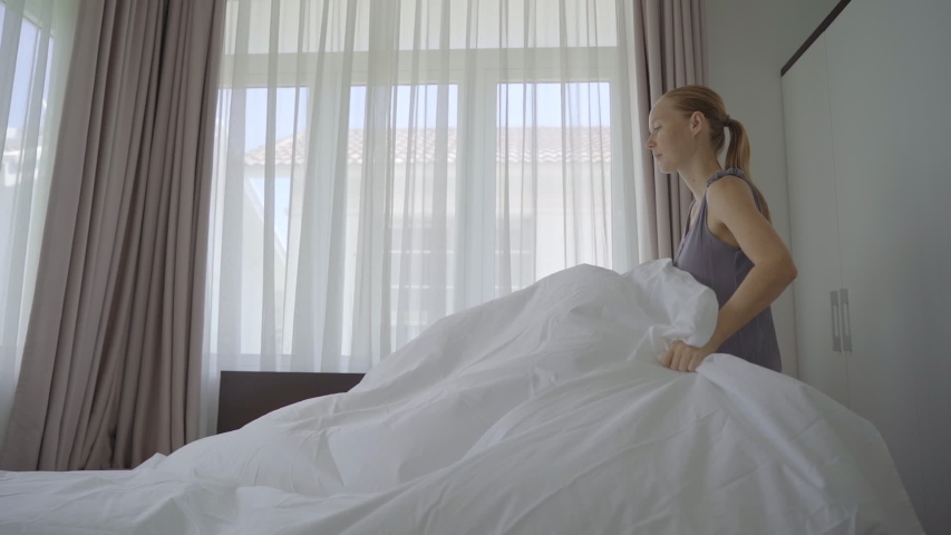 Slow-motion shot of a young woman changes bed linen in a room Royalty-Free Stock Footage #1057795954