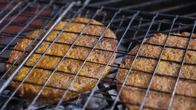 Close up of vegan meat patties in nonstick grilling basket. Making vegan burgers on barbecue. 