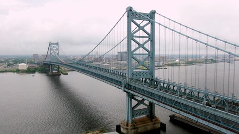 Establishing shot of Camden New Jersey NJ, Ben Franklin Bridge on hazy summer day, Delaware River at Philadelphia