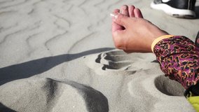 Woman hand touches and feels the fine sand of the beach. Video HD