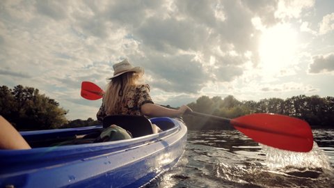 Girl In Kayak Summer Trip.Woman Exploring Calm River By Canoe On Holiday Vacation Weekend.Pretty Woman In Hat Kayaking On Lake At Sunset And Holds Oar.Girl Traveler Swim In Kayak Boat In Tranquil Pond