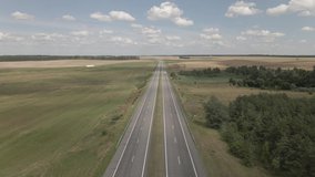 Drone video, view of the earth, highway in the countryside, field and sky on a sunny day 