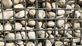 Wonderful abstract pastel background  4K video of white pebbles behind the wire .