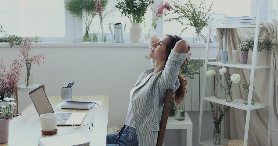 Side view peaceful young business owner stretching back muscles, relaxing at modern atelier boutique shop. Calm mindful creative designer decorator enjoying break pause moment in showroom or office. Royalty-Free Stock Footage #1057830019