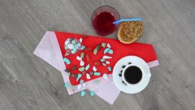 Top view spinning video of coffee cup with cookies and colored candies.
