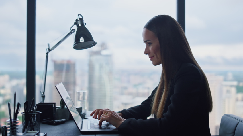 Happy businesswoman typing on laptop keyboard at remote workplace. Portrait of joyful female professional reading good news on laptop screen. Smiling business woman working on computer at home office | Shutterstock HD Video #1057837660