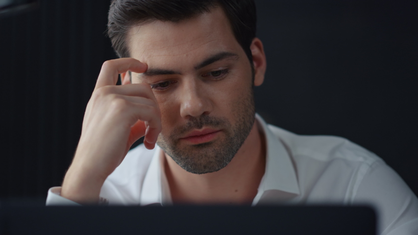 Thoughtful businessman sitting at remote workplace with laptop computer. Pensive professional thinking at table in office. Focused business man face looking around. Serious man portrait Royalty-Free Stock Footage #1057837675
