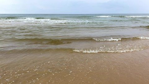 4K-Waves lapping on the beach.waves hitting the empty sandy beach.
