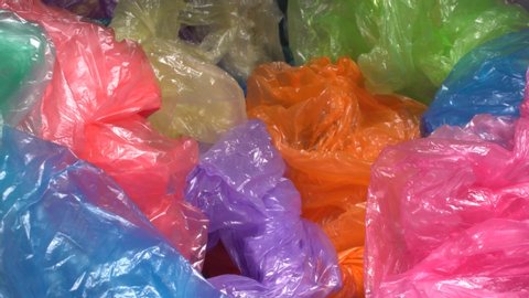 A lot of Colorful Single-use Plastic Shopping Bags throw away form a big pile. Plastic Packaging Pollution. Plastic trash in landfills and the ocean