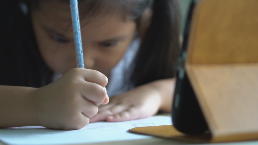 asian child student back to school or kid girl draw or write by pencil and read on computer tablet with doing homework to new idea think or people learn from home and study online on smartphone slow Royalty-Free Stock Footage #1057855930